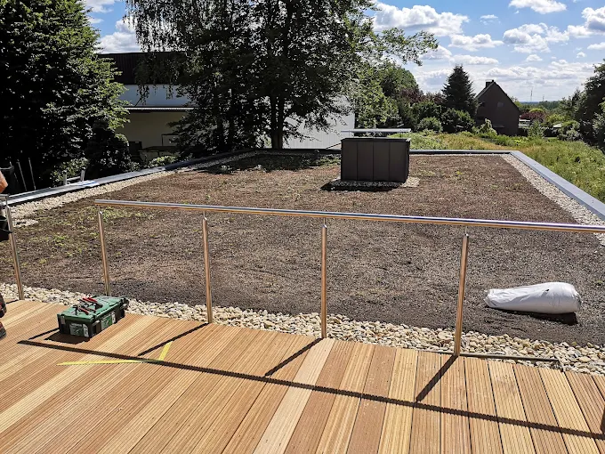Begrüntes Flachdach mit Edelstahlgeländer und Holzterrasse